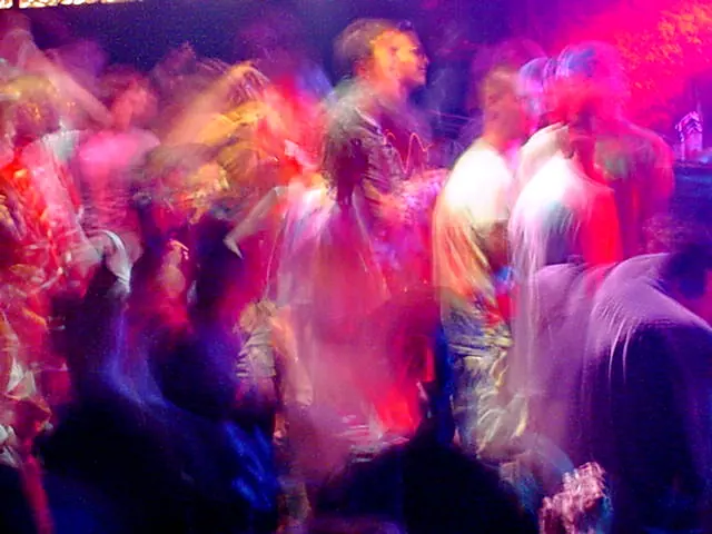 Rave dancers in natural motion - experimental digital photography by Rick Doble. Candid handheld photograph taken at 2 or 4 seconds (see EXIF data below) with an early digital camera in 2002 and shot under available light. Effects were created with photography and not created with computer graphics.