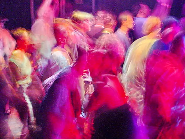 Rave dancers in natural motion - experimental digital photography by Rick Doble. Candid handheld photograph taken at 2 or 4 seconds (see EXIF data below) with an early digital camera in 2002 and shot under available light. Effects were created with photography and not created with computer graphics.