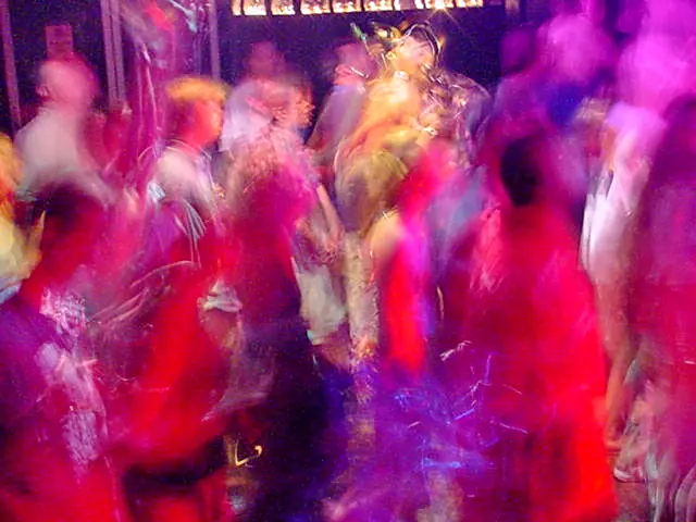 Rave dancers in natural motion - experimental digital photography by Rick Doble. Candid handheld photograph taken at 2 or 4 seconds (see EXIF data below) with an early digital camera in 2002 and shot under available light. Effects were created with photography and not created with computer graphics.