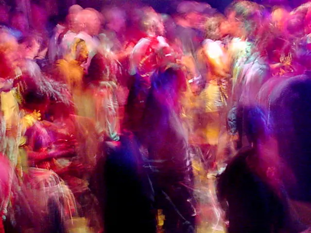 Rave dancers in natural motion - experimental digital photography by Rick Doble. Candid handheld photograph taken at 2 or 4 seconds (see EXIF data below) with an early digital camera in 2002 and shot under available light. Effects were created with photography and not created with computer graphics.