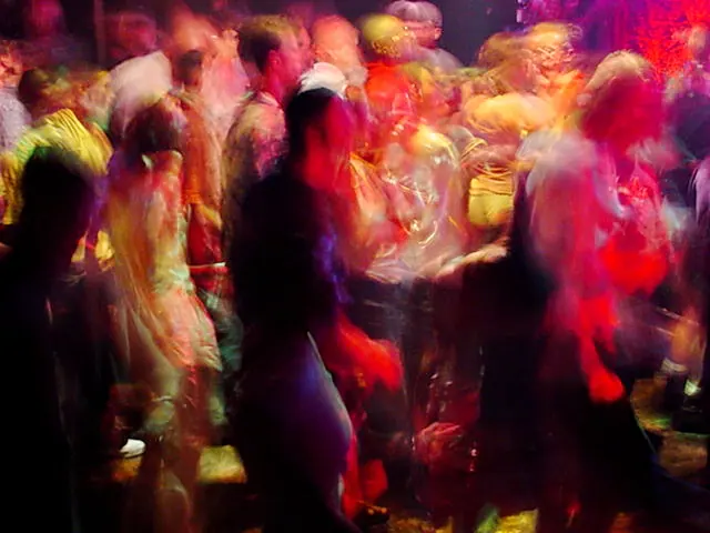 Rave dancers in natural motion - experimental digital photography by Rick Doble. Candid handheld photograph taken at 2 or 4 seconds (see EXIF data below) with an early digital camera in 2002 and shot under available light. Effects were created with photography and not created with computer graphics.