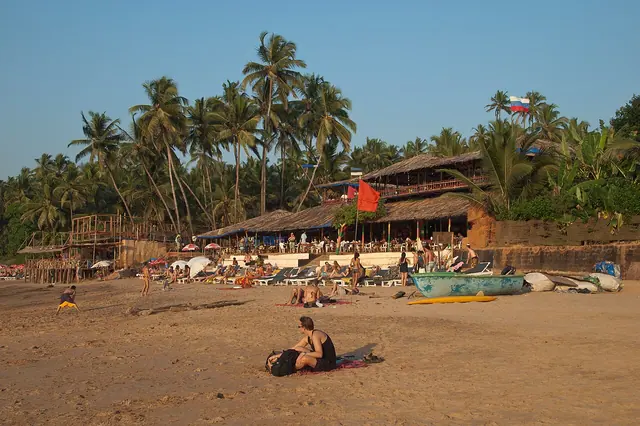 People on the beach of Anjuna. Curlies is the most popular among the Anjuna beach shacks and the oldest one (late 1980s). Curlies is for those looking to (trance) party in Goa. God is a DJ and everyone's body is a temple. Anjuna, Goa, India.