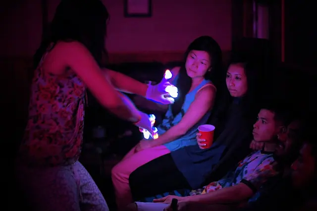 Picture of a girl giving a light show with LED gloves.
