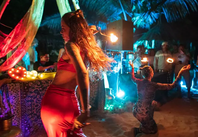 Female fire dancers at Goa trance party. Fire dancing at night. Morjim Beach, Goa, India.