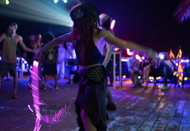 People dancing at a psychedelic trance party in Ashwem, Goa, India.